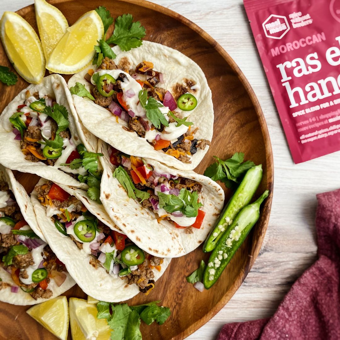 Moroccan Tacos on Wooden Plate with Packet of Spice Mix